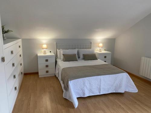 Cabana de BergantiñosCasa da Morriña的卧室配有白色的床和2个床头柜