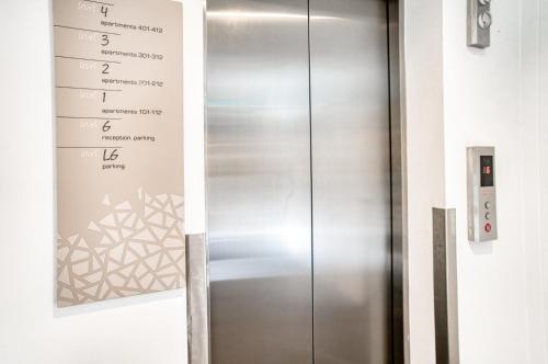 吉朗Vue Apartments Geelong的墙上有标志的金属电梯