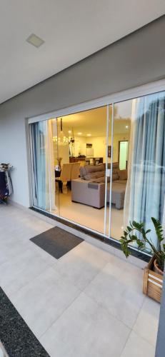 邦比尼亚斯Casa Sunstay Garden com piscina的客厅设有大型滑动玻璃窗。