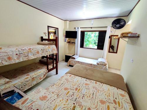 伊利亚贝拉Chalé da cachoeira - Ilhabela的带三张床和窗户的客房