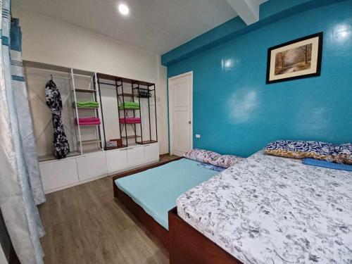 San RoqueCebu City 80sq Apartment near SM Seaside NuStar Ocean Park Dynamic Herb的一间卧室设有一张床和蓝色的墙壁