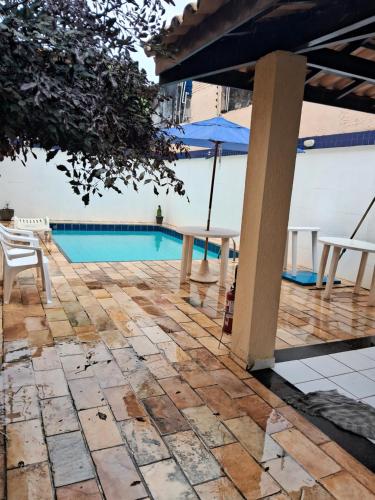 萨尔瓦多VILLAGE PÉ NA AREIA的一个带游泳池、椅子和遮阳伞的庭院