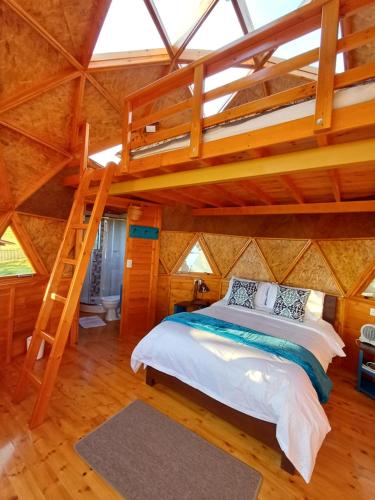 杜伊塔马Reserva Campestre LA CABAÑA GLAMPING的树屋中一间带高架床的卧室