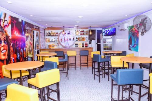 拉各斯Optimum Residence的一间带桌椅的餐厅和一间酒吧