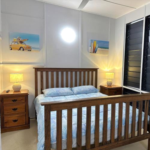 Wagait BeachUnit 1 Golden Sands Retreat的一间卧室配有木床和2个床头柜