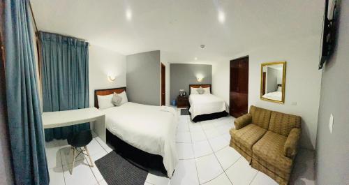 伊瓦拉Quinta San Carlos Hostel的酒店客房,设有两张床和一张沙发