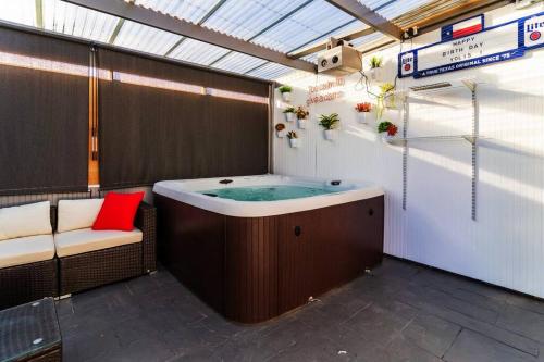 埃尔帕索Discover the Ultimate Trending Hot Tub Retreat的一个带红色枕头的按摩浴缸的房间,椅子上