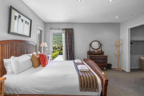 箭镇Elite Holiday Homes Queenstown - Arrowbrae的卧室设有一张白色大床和一扇窗户。
