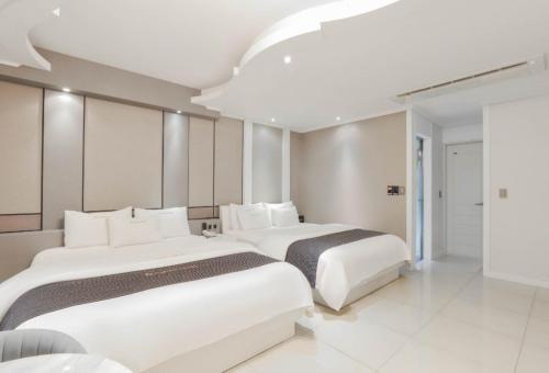 浦项Renaissance Hotel Pohang的白色的酒店客房内的两张床