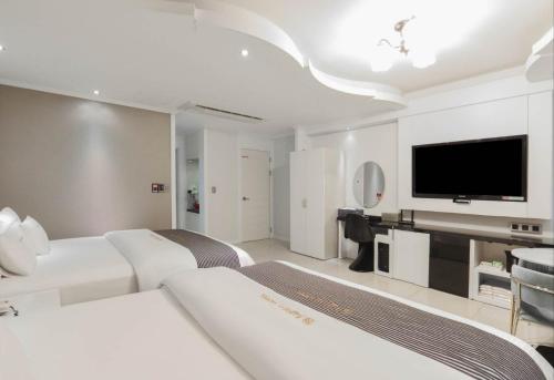 浦项Renaissance Hotel Pohang的酒店客房设有两张床和一台平面电视。