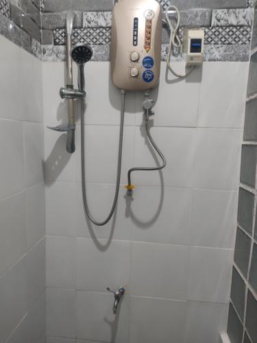 锡基霍尔Apoestin homestay的浴室设有淋浴,墙上配有吹风机