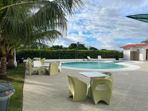 戴维Playa La Barqueta , Las Olas Tower Front的一个带椅子的庭院和一个带桌椅的游泳池