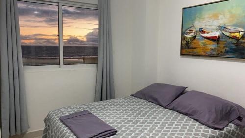 戴维Playa La Barqueta , Las Olas Tower Front的卧室配有一张床,墙上挂有绘画作品