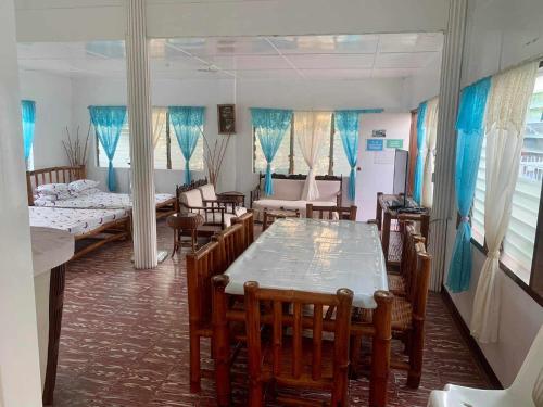 利安Tamari's Rest House的客房设有桌椅和一些床铺。