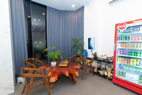 Trảng BàngGems Hotel - Khách sạn Trảng Bàng的配有桌椅和饮料冰箱的客房