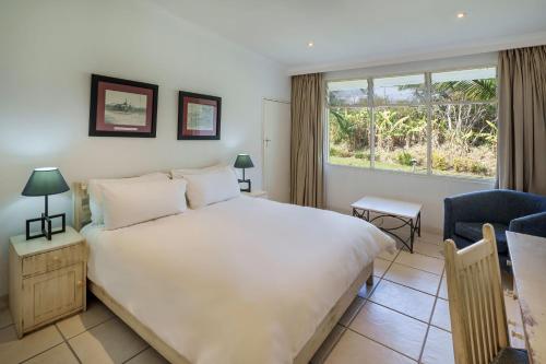钦戈拉钦戈拉普罗蒂亚酒店的卧室设有一张白色大床和一扇窗户。