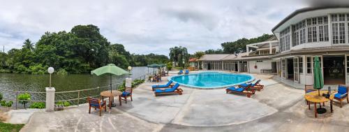 太平洋港Yatu Lau Lagoon Resort Fiji的一座带游泳池、椅子和水的房子
