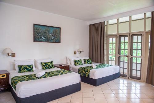 太平洋港Yatu Lau Lagoon Resort Fiji的酒店客房设有两张床和窗户。