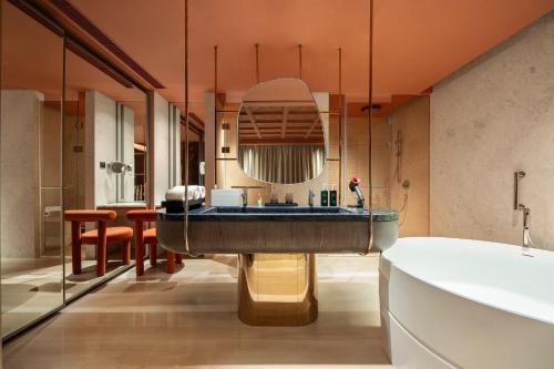 无锡Hotel Indigo Wuxi Taihu New City的一间带浴缸和大镜子的浴室
