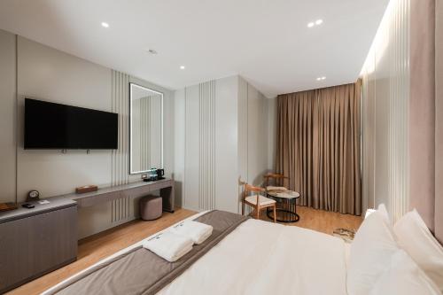 地拉那Troci Hotel的一间卧室设有一张大床和一台平面电视。