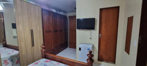 圣加布里埃尔casa da Gilvana的小房间设有衣柜和墙上的电视