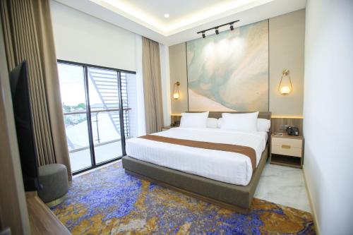 明古鲁省Two K Azana Style Hotel Bengkulu的一间卧室设有一张大床和一个大窗户