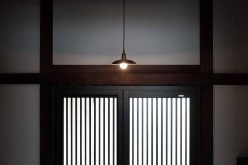 日々の宿: 宇野駅から車で5分 直島へ 最大7名様 古民家貸切 一棟貸し的挂在门上的吊灯,有窗