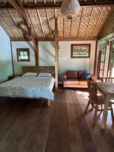 特特巴图Santai House的一间卧室配有一张床、一张沙发和一张桌子