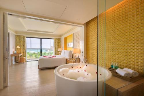 华欣华欣阿玛瑞度假酒店的带浴缸的浴室和1间带1张床的卧室