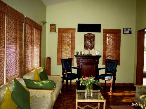 科代卡纳尔LEELA's COUNTRY HOUSE的客厅配有沙发和桌子