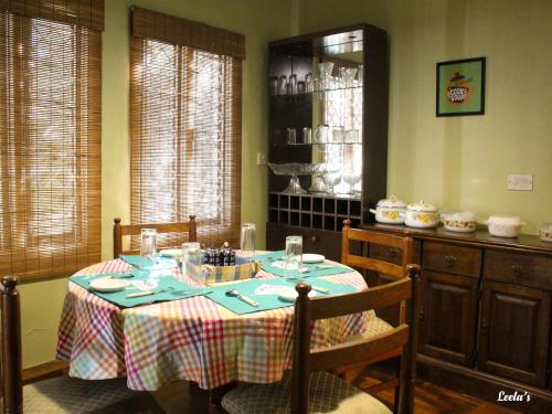 科代卡纳尔LEELA's COUNTRY HOUSE的一间用餐室,配有一张带蓝桌布的桌子