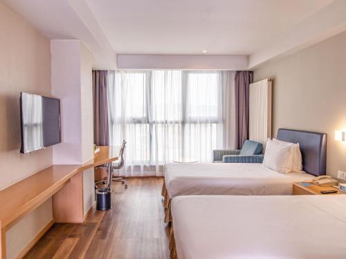 张家口张家口园景智选假日酒店 的酒店客房设有两张床和电视。
