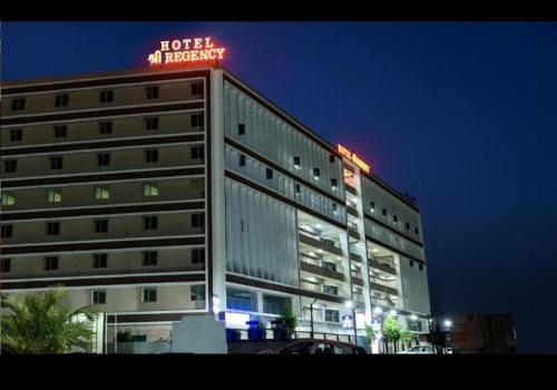 艾哈迈达巴德Hotel Shree Regency Ahmedabad的上面有 ⁇ 虹灯标志的建筑