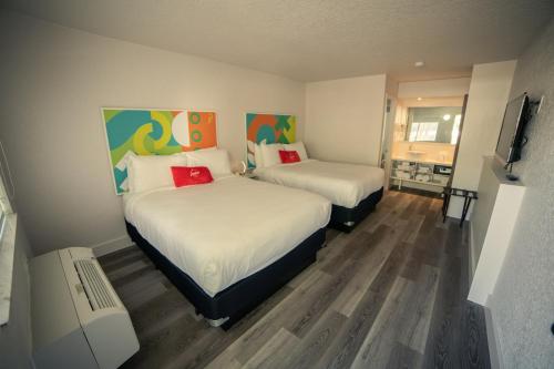 基西米Developer Inn Express Fundamental, a Travelodge by Wyndham的一间卧室配有两张床和电视。