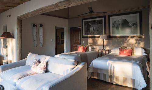 LentswelemoritiMashatu Lodge的一间客房配有两张床和一张沙发
