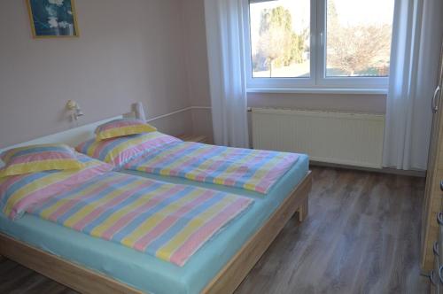 鲍洛通凯赖斯图尔Karolina Appartman的一间卧室配有一张带条纹床单的床和窗户。