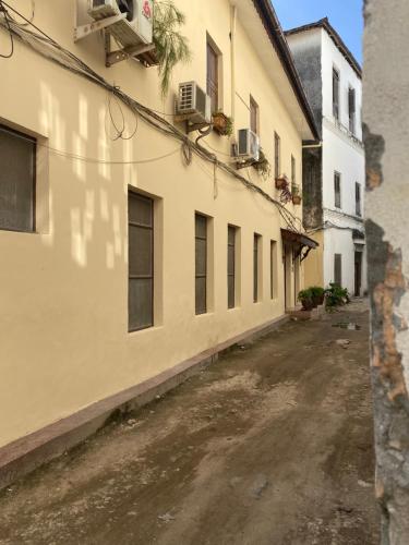 Stone TownCaravan Serai Amour的两座建筑之间的小巷里一条空的街道