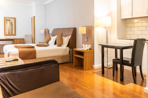 亚的斯亚贝巴Bonanza Addis Hotel的一间卧室配有一张床和一张桌子及椅子