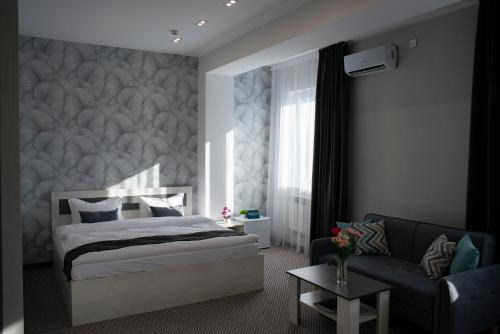 阿克套Tengri Hotel的一间卧室配有一张床和一张沙发