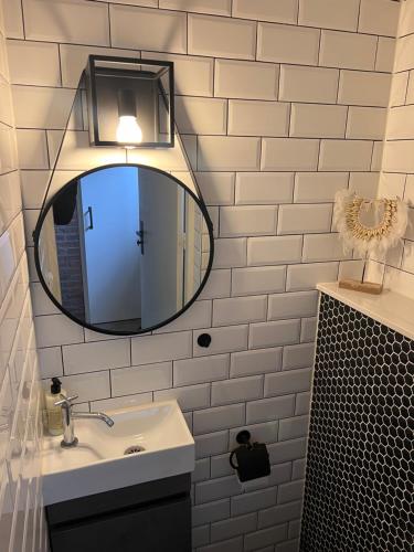 格罗宁根Short Stay house in Groningen的一间带镜子和水槽的浴室