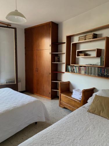 勒·雷约尔·卡纳德尔·苏尔Maison Les Mimosas的一间卧室配有一张床、一把椅子和一个橱柜