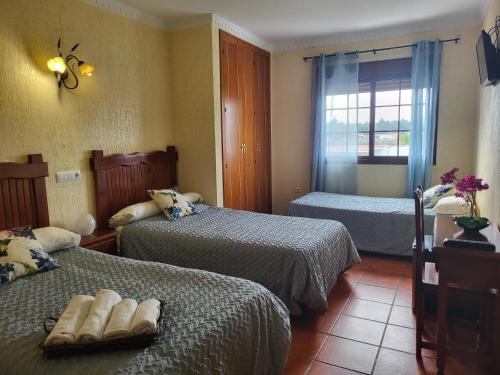阿尔科斯-德拉弗龙特拉Hostal Rural La Plata Parking Incluido的一间卧室设有两张床和窗户。
