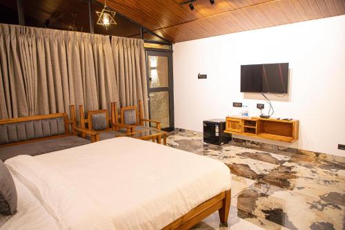 KondivliWhite Sand Beach Resort的一间卧室配有一张床和一台平面电视