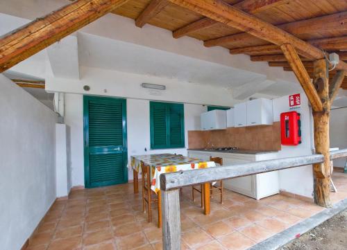 特罗佩阿Accommodetion "Mare Grande"的厨房配有桌子和一些绿色百叶窗