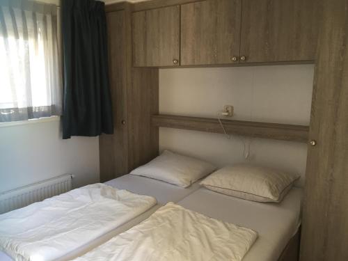 BiggekerkeMeerchalets的带窗户的客房内设有两张单人床。