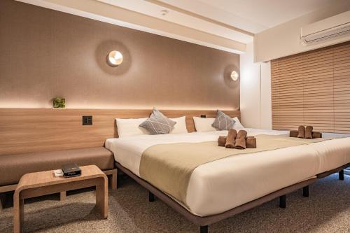 大阪住一心斋桥店的酒店客房设有两张床和一张桌子。
