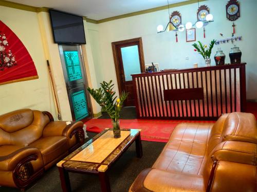 阿克拉hongyuanprimierhotel的客厅配有皮革家具和桌子