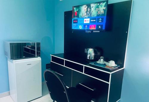肯普顿帕克Goldwel Lodge的蓝色的客房配有一张桌子、一把椅子和一台电视机