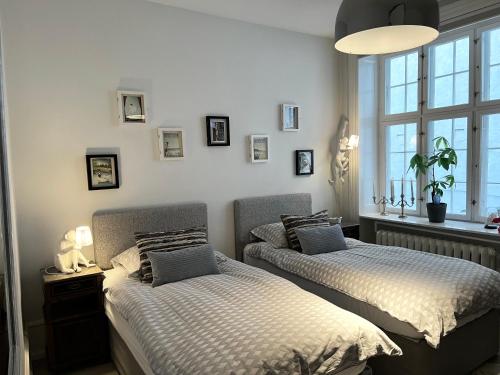 哥本哈根Camillas Holiday home Copenhagen City Centre的一间卧室设有两张床和窗户。
