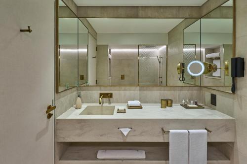 阿布扎比ERTH Abu Dhabi Hotel的一间带水槽和大镜子的浴室